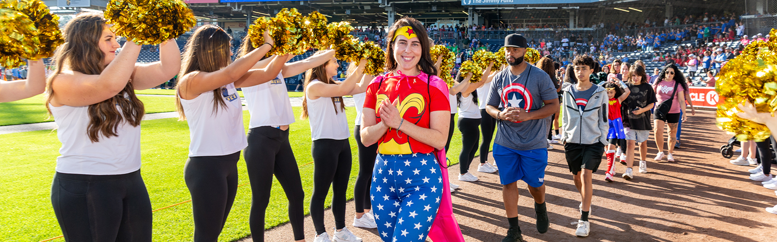 Cancer survivors taking part in the survivor lap on the warning track of Polar Park